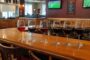 Six glasses of red wine lined up on the bar at Adam's Grille Kent Island for Half-Price Wine Wednesday